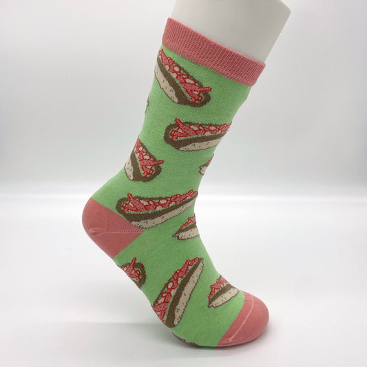 A white sock mannequin sports agreen sock pattern with lobster rolls. The welt, heel and toe of the sock are pink.