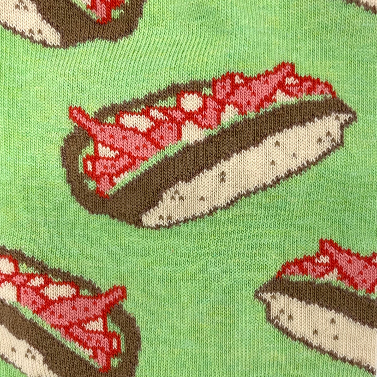 A close-up shot shows a lobster roll pattern woven into a green sock.