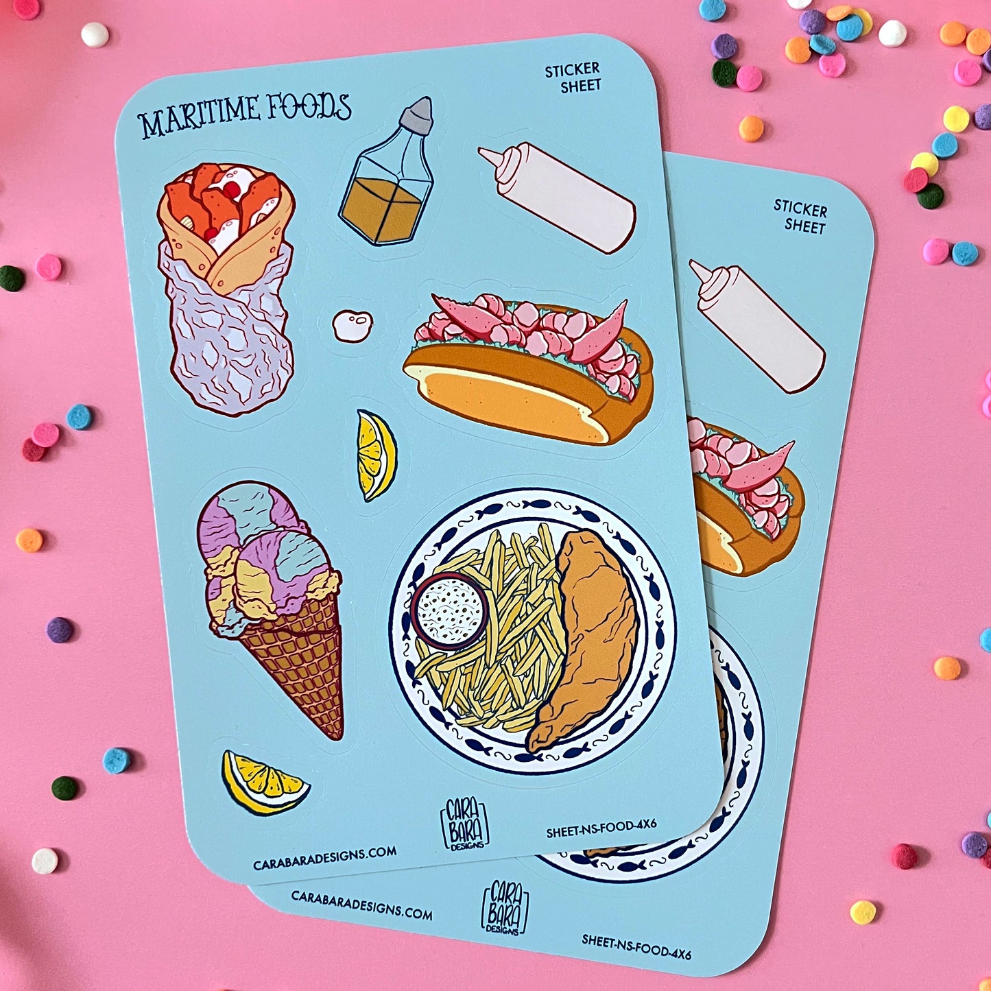 Two colourful sticker sheets full of Nova Scotia foods lie against a pink background.