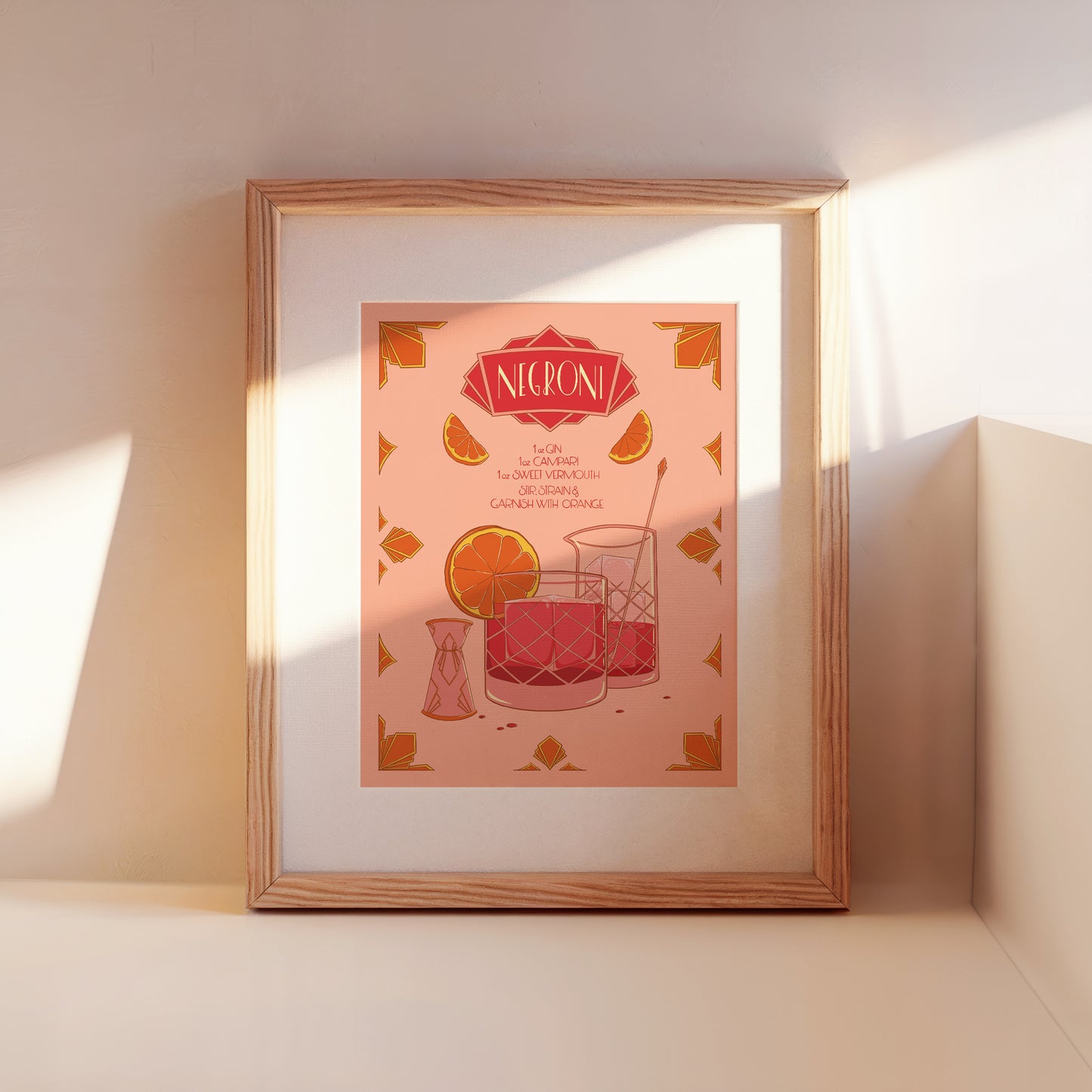 A framed illustrated cocktail recipe for a negroni leans against a wall.