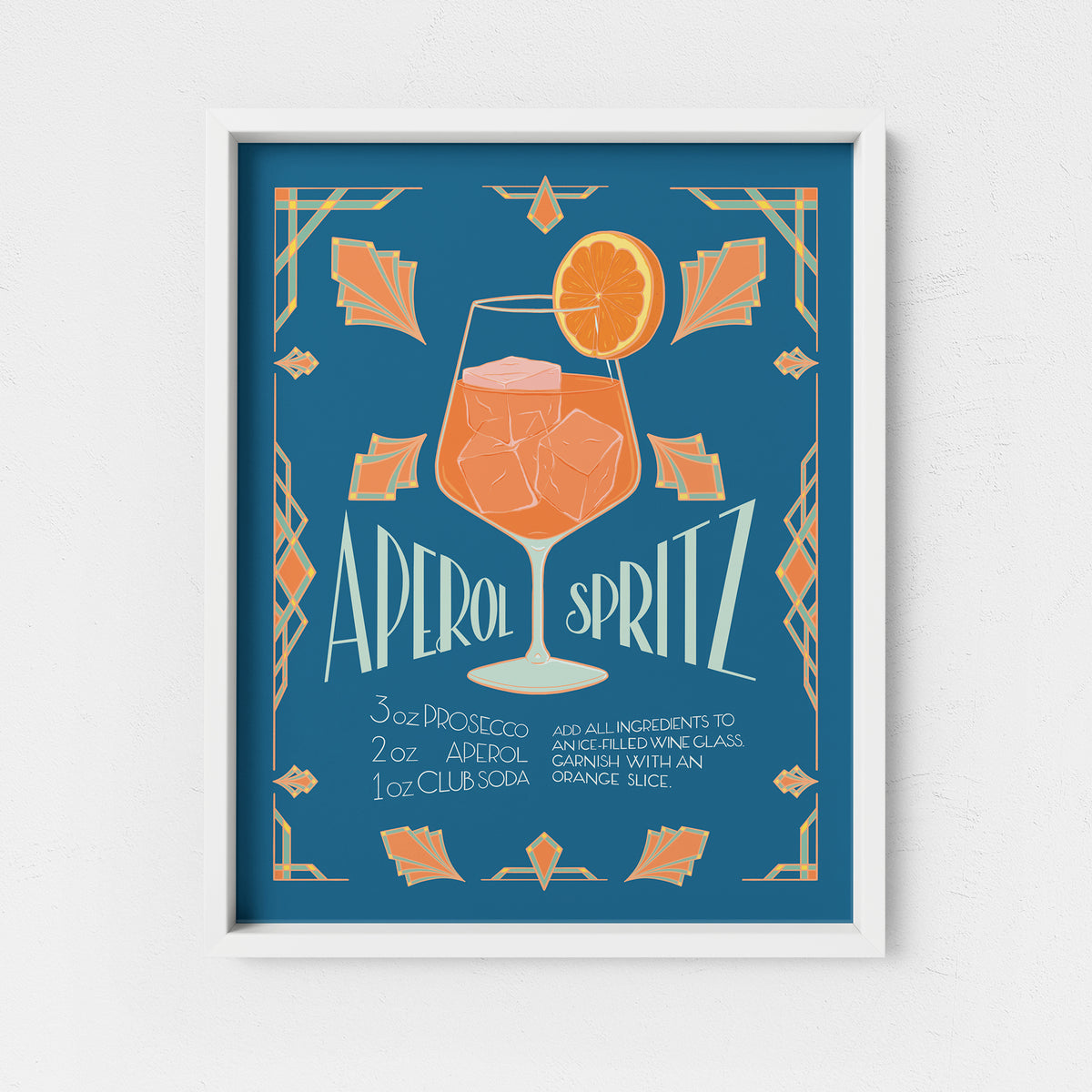 An art print featuring an art deco style orange aperitivo spritz cocktail recipe is in a white frame.