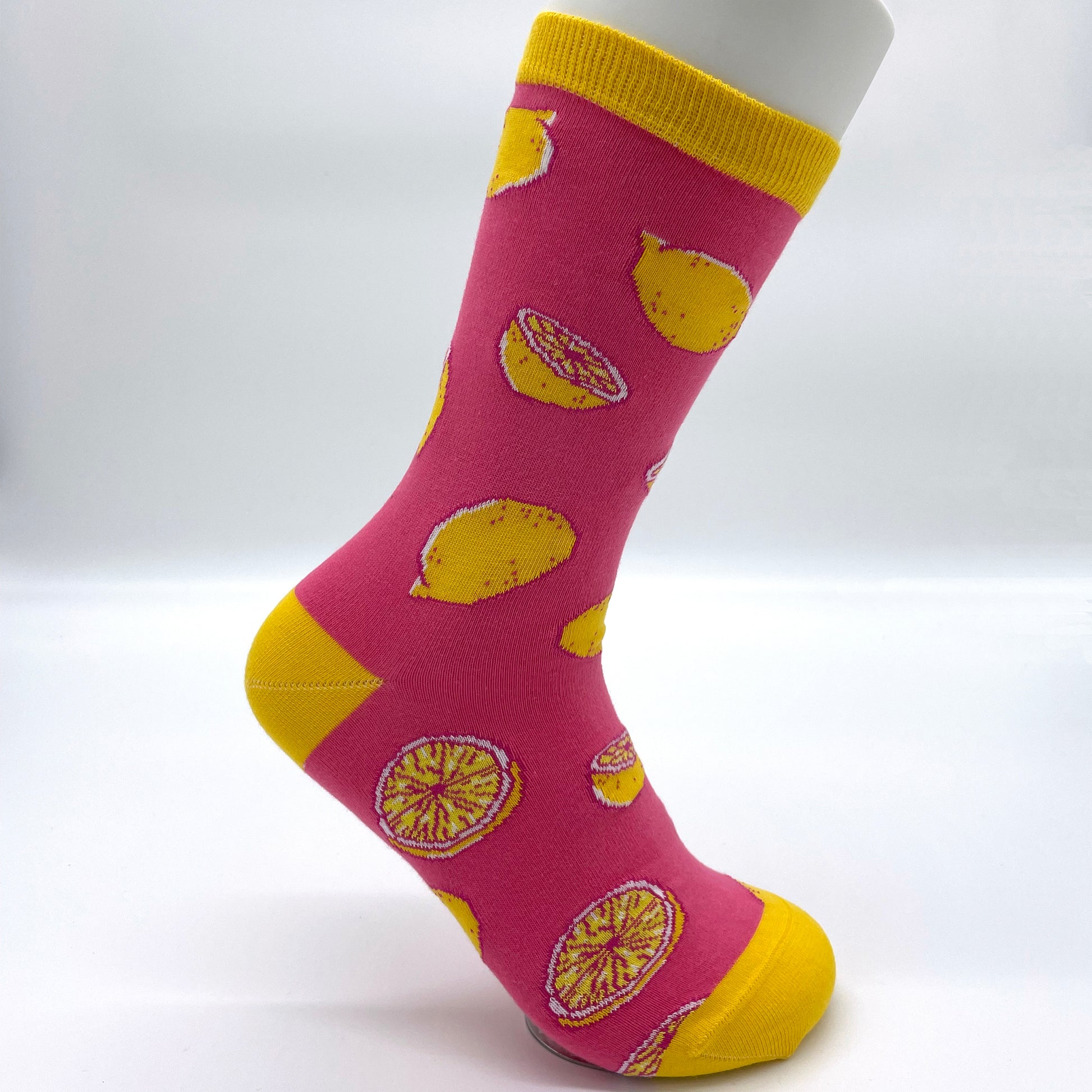 A white sock mannequin sports a pink sock patterned with yellow lemons. The welt, heel and toe are yellow.
