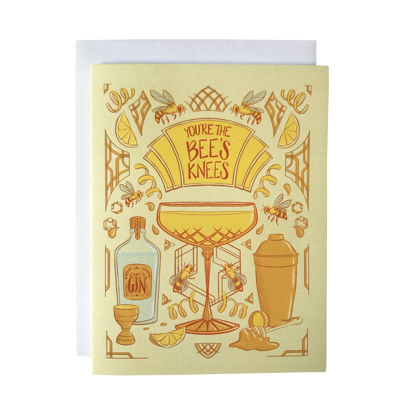 A yellow art-deco inspired greeting card is covered with illustrations of bees, honey and cocktail accessories, along with a crystal coupe filled with a Bee's Knees cocktail. A marquee on the card reads You're the Bee's Knees in dark orange letters. The card sits against a white envelope on a white background.