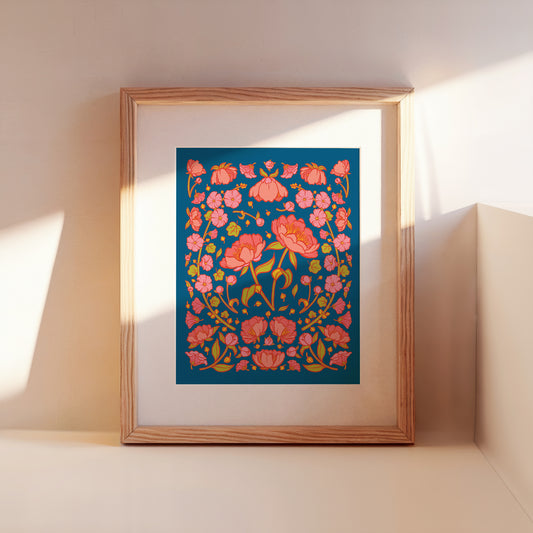 A framed art print of pink peonies on a blue background leans against a wall.