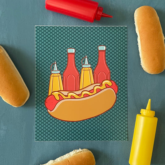 A hot dog in a bun with mustard drizzled on top is in front of alternating ketchup and mustard bottles on a blue polka dot background. It sits among hot dog buns and squeeze bottles of ketchup and mustard.