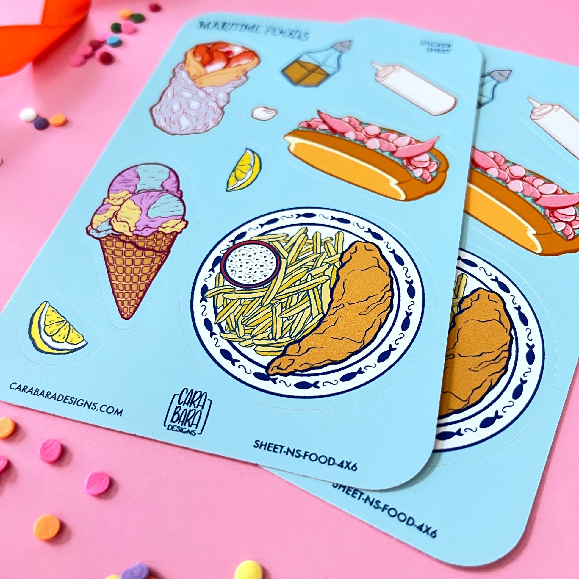 Two colourful sticker sheets full of Nova Scotia foods lie against a pink background.