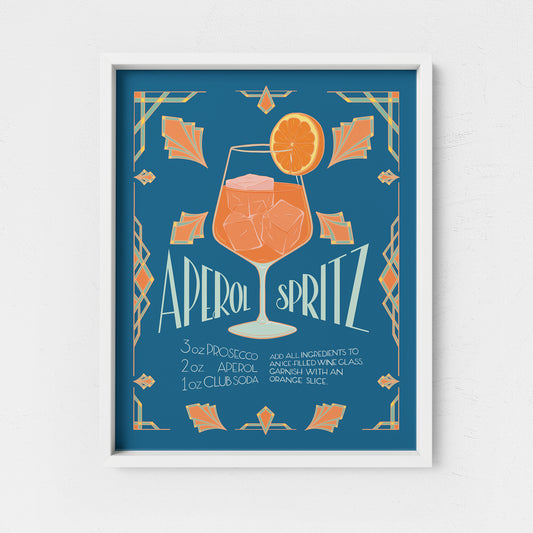 An art print featuring an art deco style orange aperitivo spritz cocktail recipe is in a white frame.