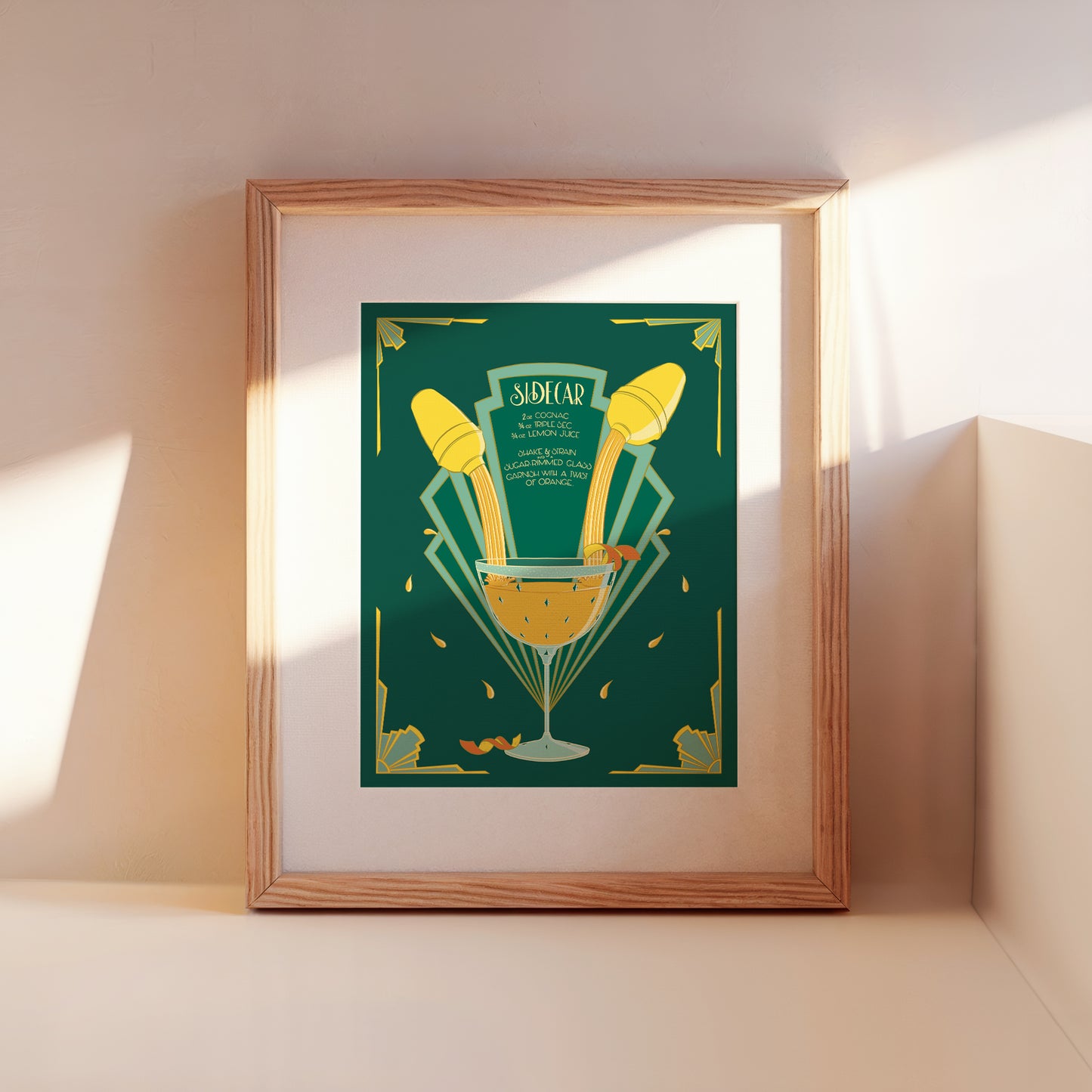 A framed illustrated cocktail recipe for a sidecar leans against a wall.