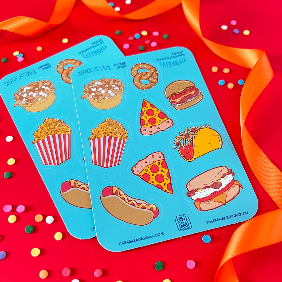 Sticker sheets featuring pizza, hot dogs, burgers and more are on red with confetti and orange ribbon.