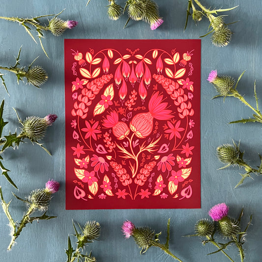 A pink and yellow illustration of thistles and other wildflowers in a full, folk-art style composition. Other flowers include lupies, echinacea, and haskap blossoms. The print is surrounded by thistles.