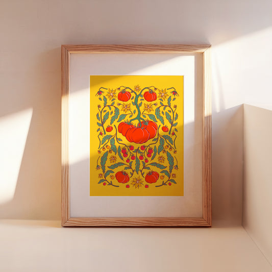 A framed tomato folk floral art print leans against a wall.