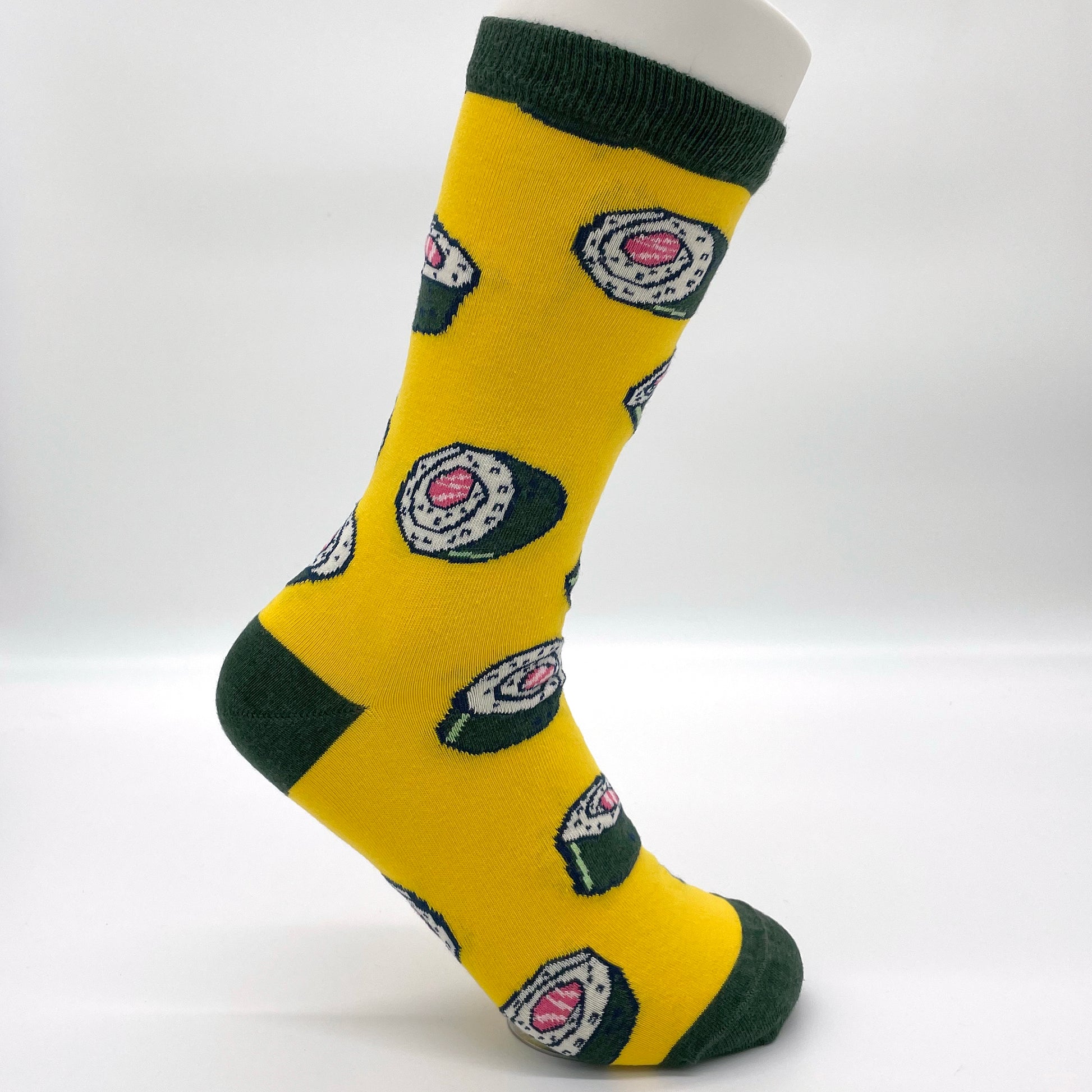 A white sock mannequin sports a yellow sock patterned with sushi rolls. The welt, heel and toe of the sock are all dark green.
