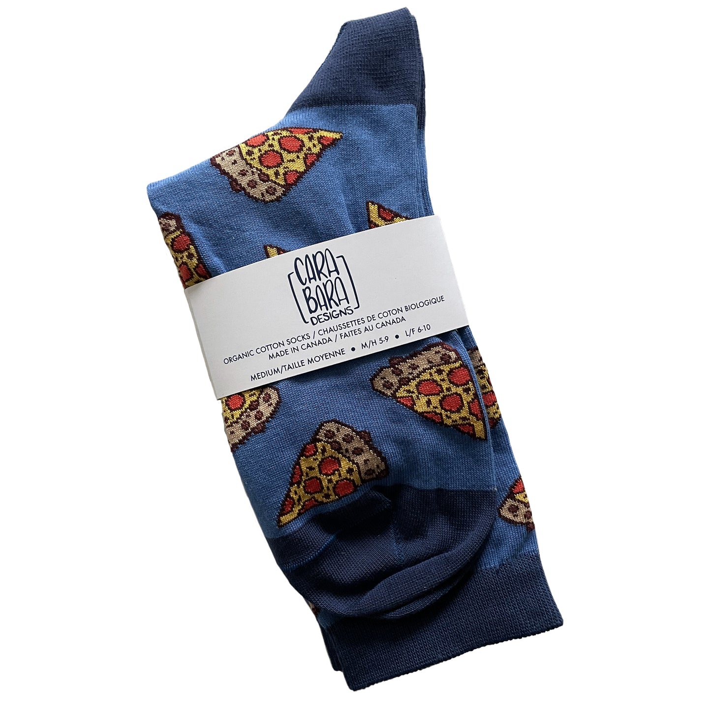 A blue pair of socks has darker blue accents is patterned with pizza slices. It is folded and labelled with a belly band with the Carabara Designs logo and the words organic cotton socks made in Canada, size medium, in English and French.
