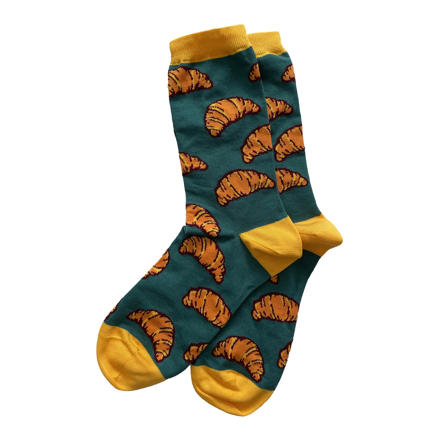 A pair of dark green socks is patterned with orange-and-yellow croissants with dark brown outlines. The cuffs, heels, and toes of the socks are yellow.